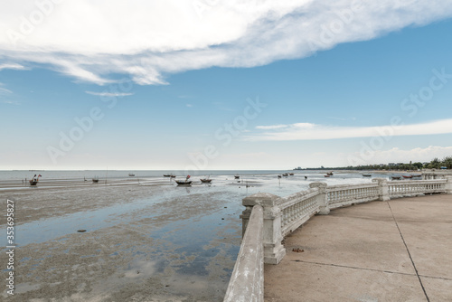 beach of Bangsaen during low tide against a blue sky with white clouds © Erik