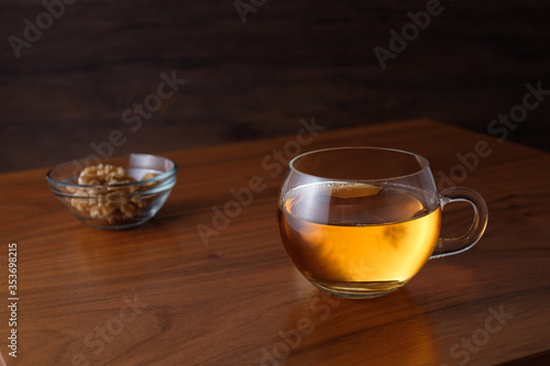 Glass cup of black tea on wooden table