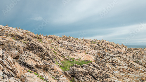 rocky hillside with blue and white sky, at the island of Koh Samet