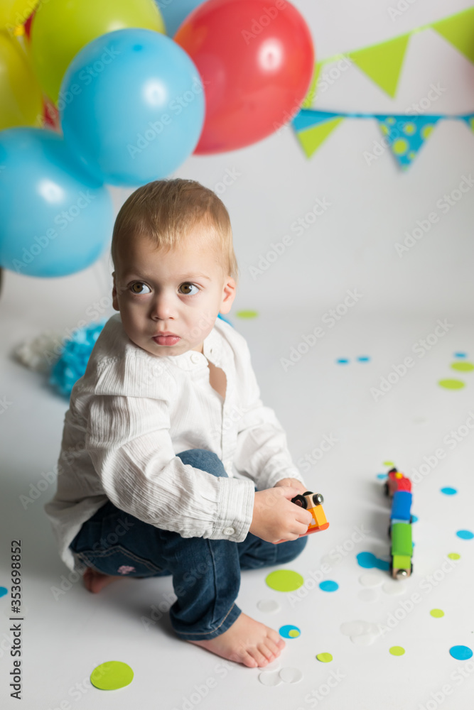 Obraz premium surprised child on his birthday. birthday photo zone with flags and balloons
