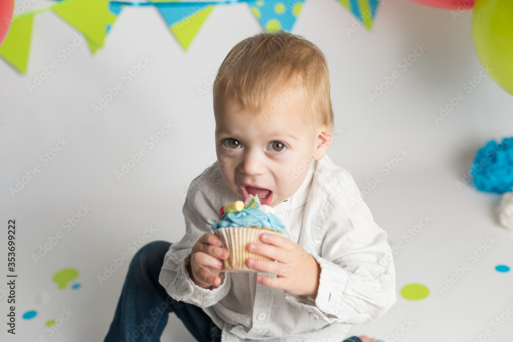 Birthday party. little boy eating his holiday cupcakes Birthday party. little boy eating his holiday cupcakes