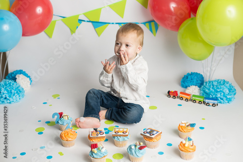 Birthday party. little boy eating his holiday cupcakes