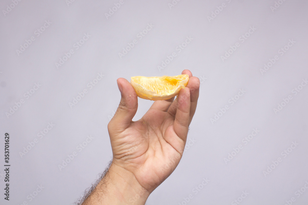 an orange in hand. isolated on a white background