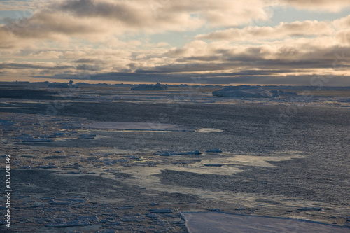 Antarctica landscape with ice and icebergs at sunset on a winter day