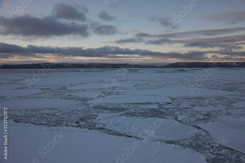 Antarctica landscape with ice and icebergs at sunset on a winter day