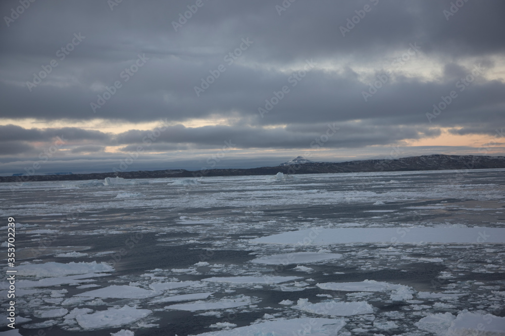 Antarctica landscape with ice and icebergs at sunset on a winter day