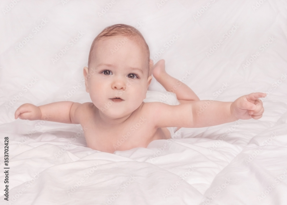 Sweet little baby boy sitting on his tummy, white background Sweet little baby boy sitting on his tummy, white background