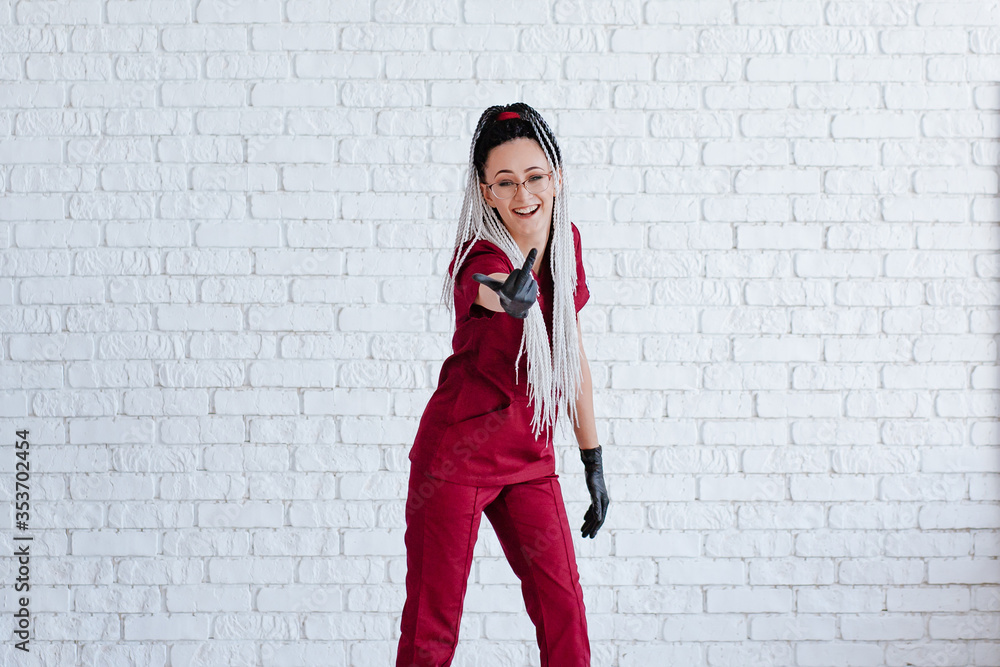girl in red medical uniform and black gloves with african pigtails shows FAQ. girl in red medical uniform and black gloves with african pigtails shows FAQ.