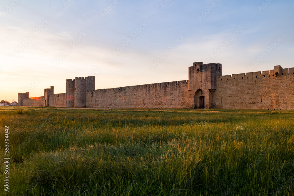 Vue au coucher du soleil sur les remparts et l'une des portes fortifiées de la ville médiévale d'Aigues-Mortes (Occitanie, France)