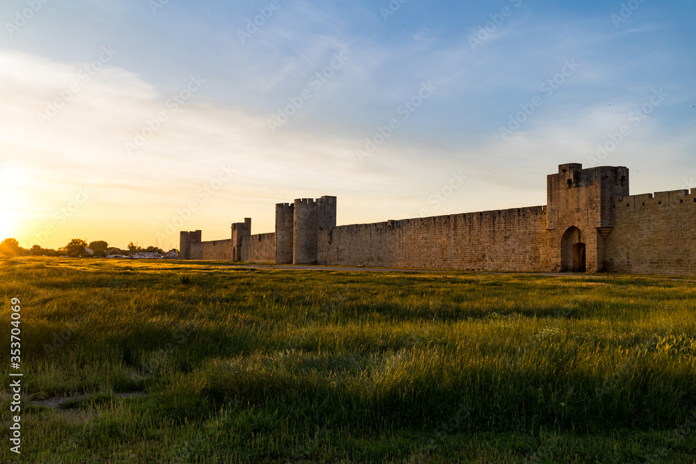 Vue au coucher du soleil sur les remparts et l'une des portes fortifiées de la ville médiévale d'Aigues-Mortes (Occitanie, France)