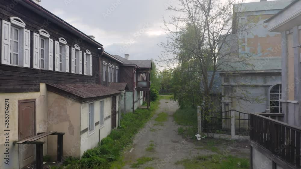 Ghost (haunted) town with an abandoned houses on a deserted street. Aerial low angle view Ghost (haunted) town with an abandoned houses on a deserted street. Aerial low angle view