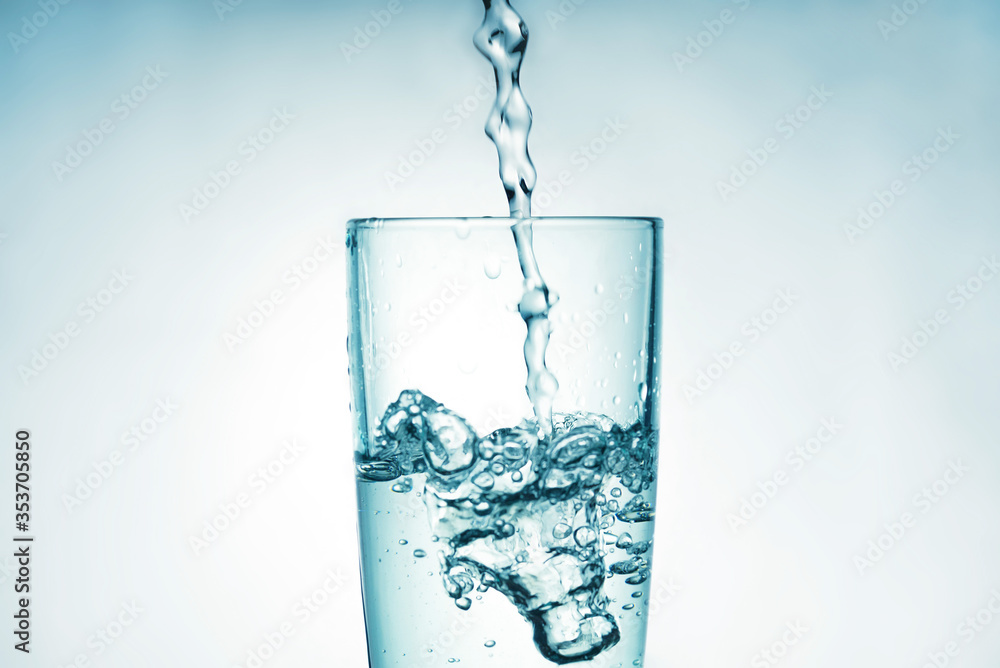 Close up of pouring purified drinking water from a bottle with bubbles and splashes on a white background Close up of pouring purified drinking water from a bottle with bubbles and splashes on a white background