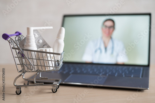 Online doctor. Medical worker at a remote consultation. A computer application for the purchase of medicines in a pharmacy with home delivery. Pharmacist on laptop screen and trolley full of drugs.