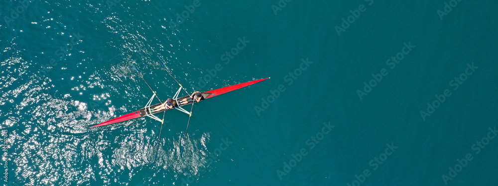 Aerial drone ultra wide photo of young women athletes rowing in canoe ...