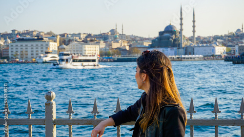 Canvas Print Woman watching Bosphorus in Karakoy or Eminonu, European side of Istanbul City under blue sky