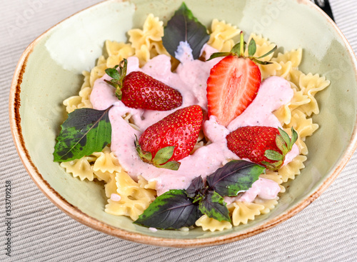 Pasta with strawberry cream and fresh strawberries and basil