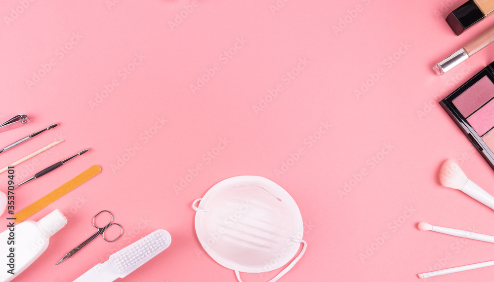 Nail salon and hair salon, after quarantine, on pink
background with 
 face mask , hand sanitizer, makeup, nail polish, makeup brushes and nail set. copy space.
Reopening concept. 