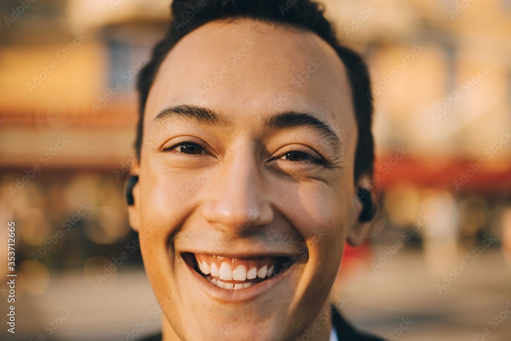 Close-up portrait of smiling young man in city Close-up portrait of smiling young man in city