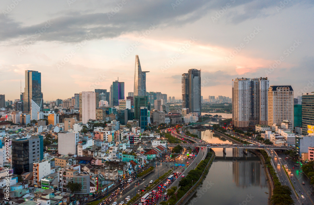 Aerial cityscape of Ho Chi Minh City in early evening with Saigon river, residential area and business skyscrapers
