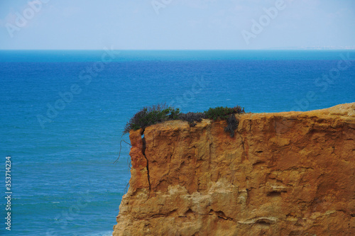 Cliff by the beach Praia da Boca Velha, Lisbon, Portugal. Costa de Caparica. Atlantic Ocean, sunny day. 
