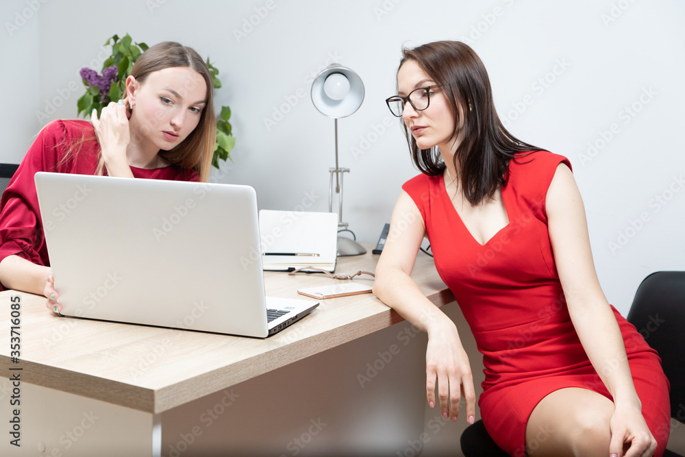 business and beautiful woman in a red dress working in the office at the computer business and beautiful woman in a red dress working in the office at the computer