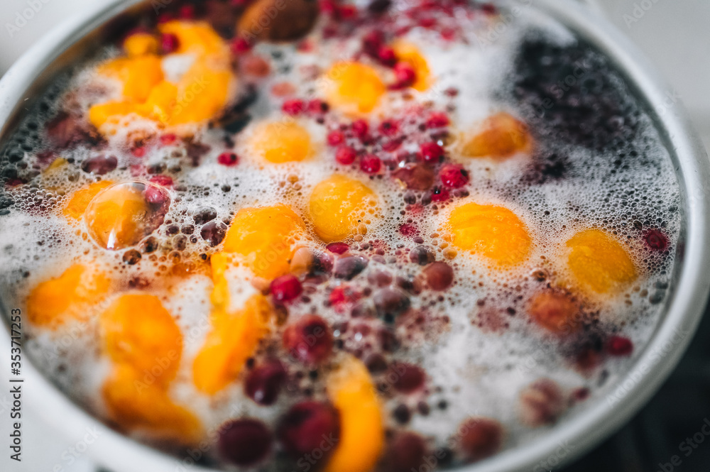 Fresh fruits are boiled in boiling water in a metal pan on a stove with bubbles and foam close-up. Cooking a delicious compote of apricot, apples, cherries, raspberries. Photography, concept. Fresh fruits are boiled in boiling water in a metal pan on a stove with bubbles and foam close-up. Cooking a delicious compote of apricot, apples, cherries, raspberries. Photography, concept.