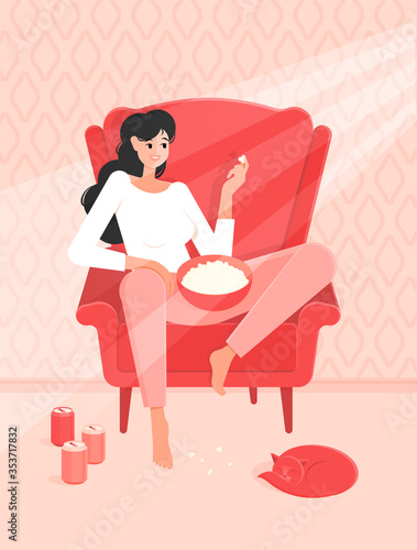 A girl in pajamas is sitting in red chair with popcorn and is going to watch a movie in rays of the sun. Colorful vector illustration in flat cartoon style. Sleeping cat.