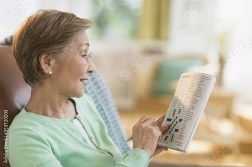 Senior woman doing crossword puzzle photo