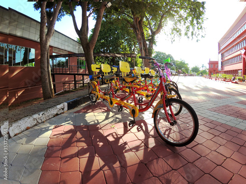 Three-seater bicycles parked on the street © Antonio
