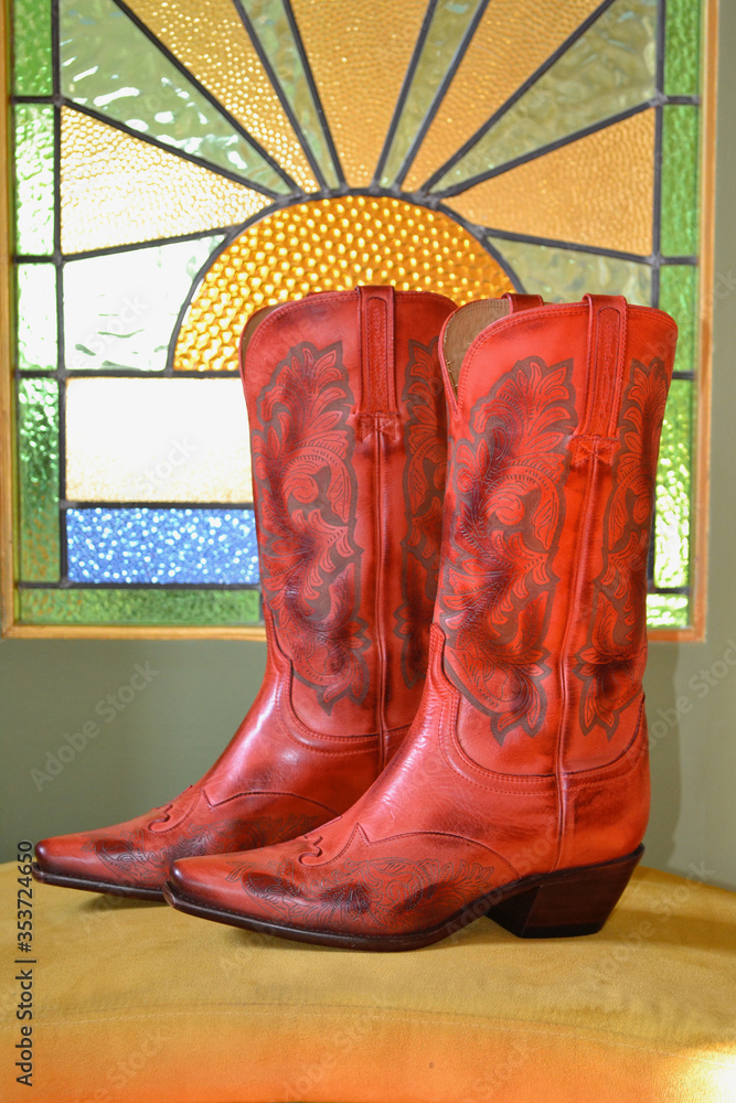Red cowboy boots on a yellow stool with a stained glass art deco background  Stock Photo | Adobe Stock