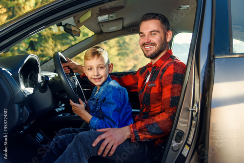 Father gives his son driving lessons, enjoying time together