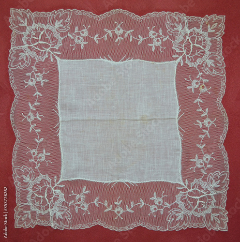Vintage linen and lace handkerchief on a rose background suitable as a frame or background