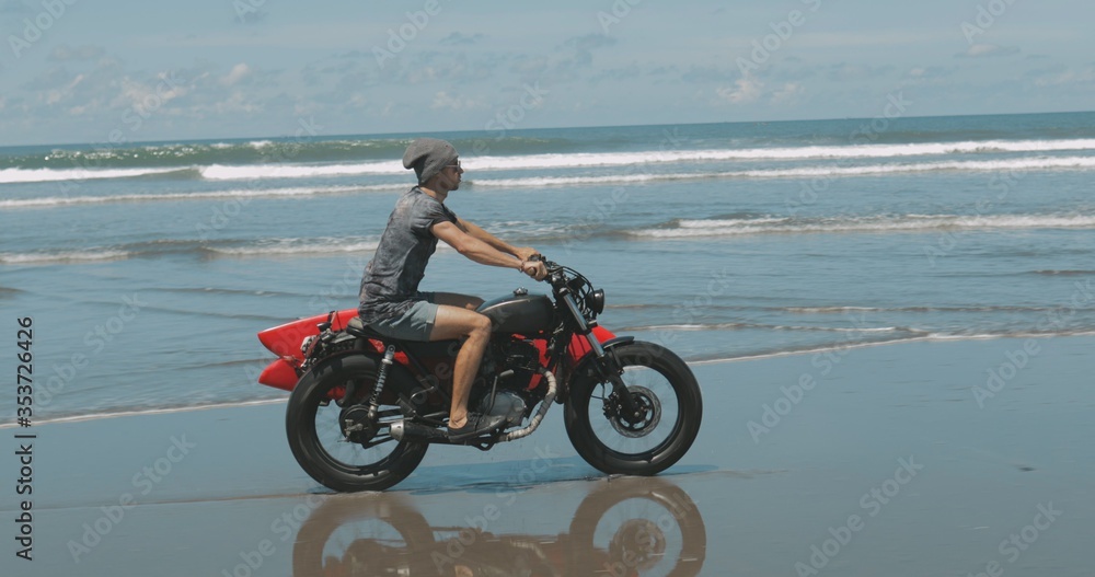 Obraz premium Motorcyclist driving his motorbike on the beach