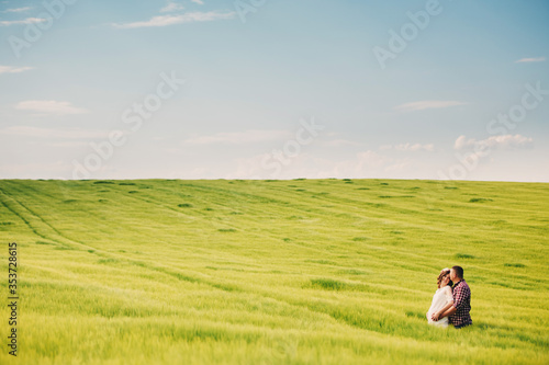 waiting baby. Parenthood. Pregnant young woman and her husband are happy to hold hands, going in the outdoor in the field of green grass background. selective focus. © Andriy Medvediuk