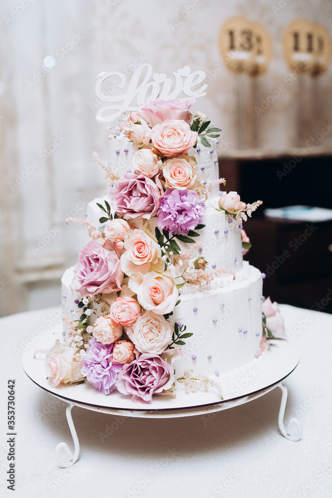Cake traditional anniversary birthday wedding three-layer. White wedding cake with pink flowers for wedding banquet. Delicious wedding reception. Copy space. Celebration party concept. Trendy Cake.