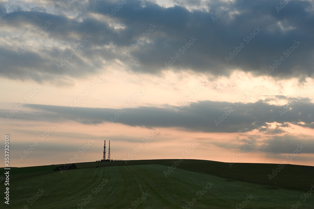 beautiful sunset with a telecoms or radio mask on the horizon with a dramatic sky 