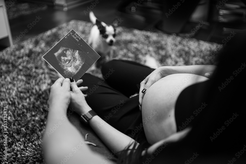 Cropped image of beautiful pregnant woman and her handsome husband holding a sonogram. Pregnancy, maternity, preparation and expectation concept