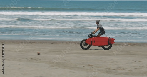 Motorcyclist driving his motorbike on the beach