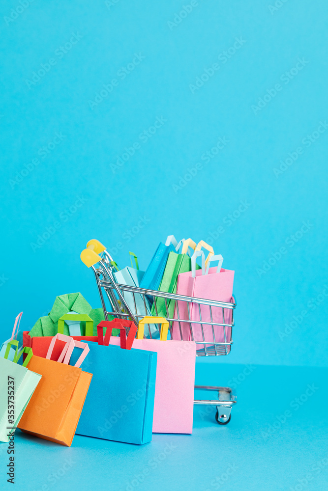 Fototapeta premium Shopping basket full of paper bags. Sesonal sale, online deals, discounts, promotions idea