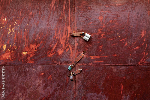 Rusty garage door is closed with three locks