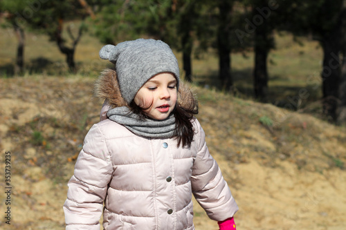 Wallpaper Mural A little cute girl in a hat with ears and a scarf stands on the background of autumn blurry hills in the background Torontodigital.ca