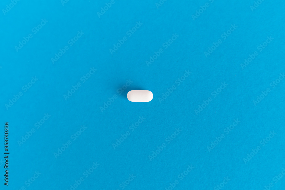 white pill antibiotic antiviral medicine on a blue background white pill antibiotic antiviral medicine on a blue background