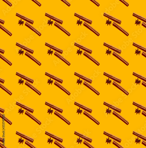 Cinnamon quills and star anise fruits seamless pattern isolated on yellow photo