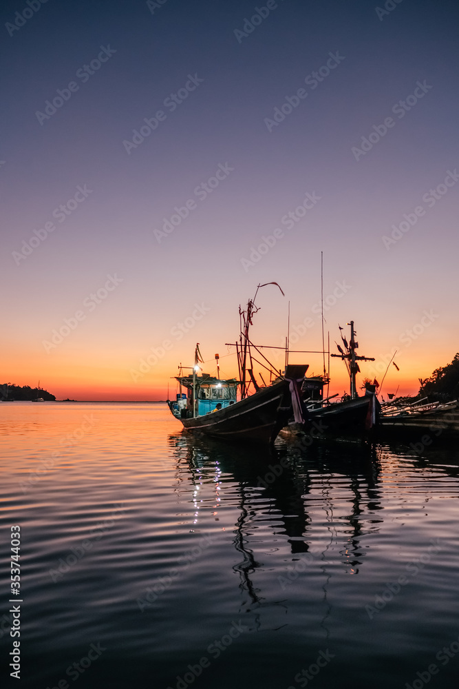 Traditional thai fisghing boats in the sea at twilight in Thailand