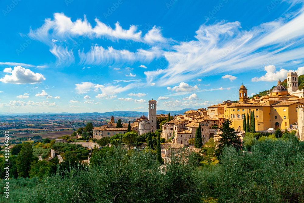 Veduta della città di Assisi, Umbria, Italia, città natale di San Francesco di Assisi e luogo di pellegrinaggio, con cielo blu e nuvole bianche