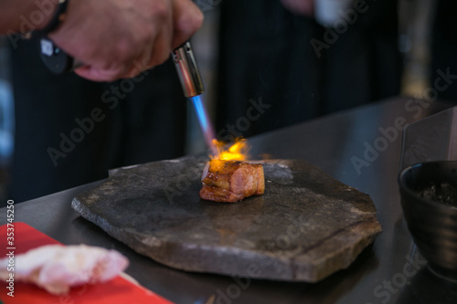 chef fry a meat medallion with a kitchen soldering iron