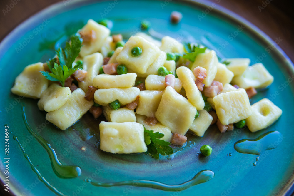 gnocchi with green peas and bacon served on a beautiful plate gnocchi with green peas and bacon served on a beautiful plate