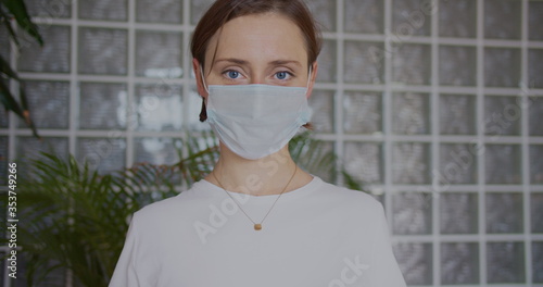 Smiling and happy positive cured pandemic woman takes off her medical mask of coronavirus protection and takes a deep breath after self isolation at home.Concept of healthcare and safety SARS-CoV-2