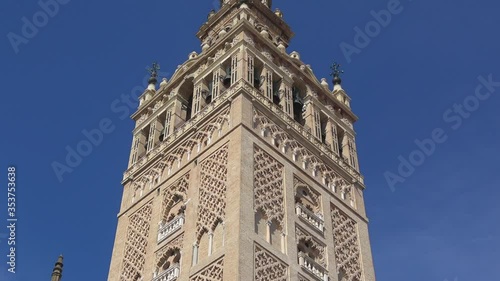 4K. Ultra HD. View of La Giralda Tower with a clear blue sky in the background. Bell tower of the cathedral. The largest cathedral in the world located in Seville, Spain. 