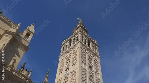 4K. Ultra HD. View of La Giralda Tower with a clear blue sky in the background. Bell tower of the cathedral. The largest cathedral in the world located in Seville, Spain. 